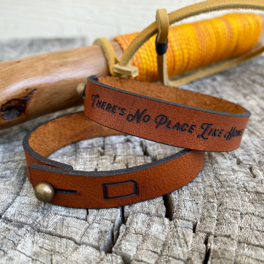 Leather bracelets by Kinfolk sitting atop a tree trunk.